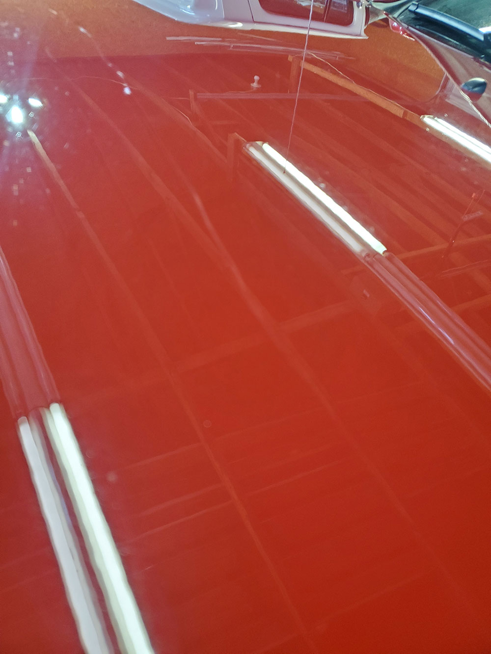 Red truck hood with racing stripes